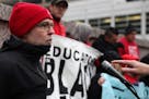 Nick Faber, president of the St. Paul Federation of Teachers, spoke as others held signs while they protested at a CEO luncheon outside the Hilton hot