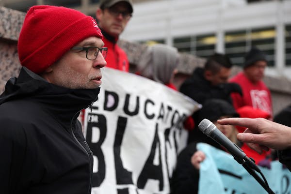 Nick Faber, president of the St. Paul Federation of Teachers, spoke as others held signs while they protested at a CEO luncheon outside the Hilton hot