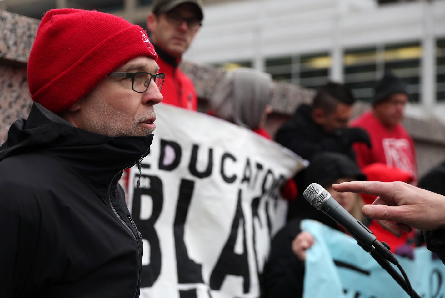 Nick Faber, president of the St. Paul Federation of Teachers, spoke as others held signs while they protested at a CEO luncheon outside the Hilton hotel. ] ANTHONY SOUFFLE &#xef; anthony.souffle@startribune.com Nick Faber, president of the St. Paul Federation of Teachers, spoke during a protest of a CEO luncheon Wednesday, Nov. 15, 2017 outside the Hilton hotel in downtown Minneapolis. The protesters said they will call on corporations to fund the schools just as they're funding the Super Bowl w