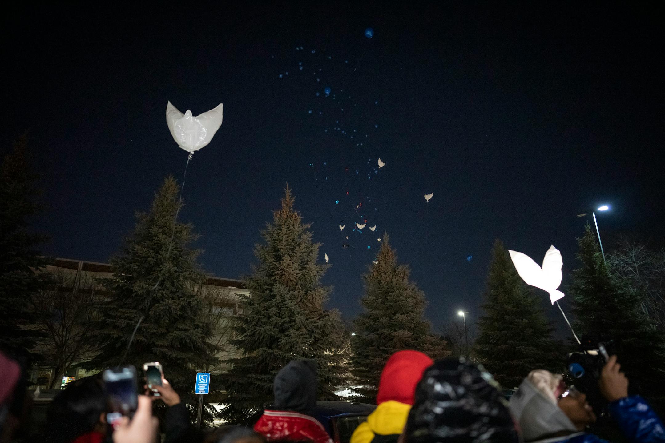 Friends, family and teachers of Jahmari Rice release balloons, including dove shaped balloons during a vigil for the one year anniversary of the death of 15-year-old Jahmari Rice.