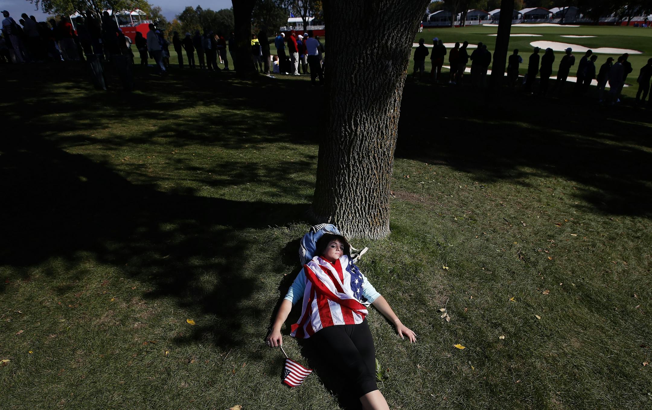 Angela Erhart, 25, Chanhassen rested under a tree during the Ryder Cup at Hazeltine National Golf Club.