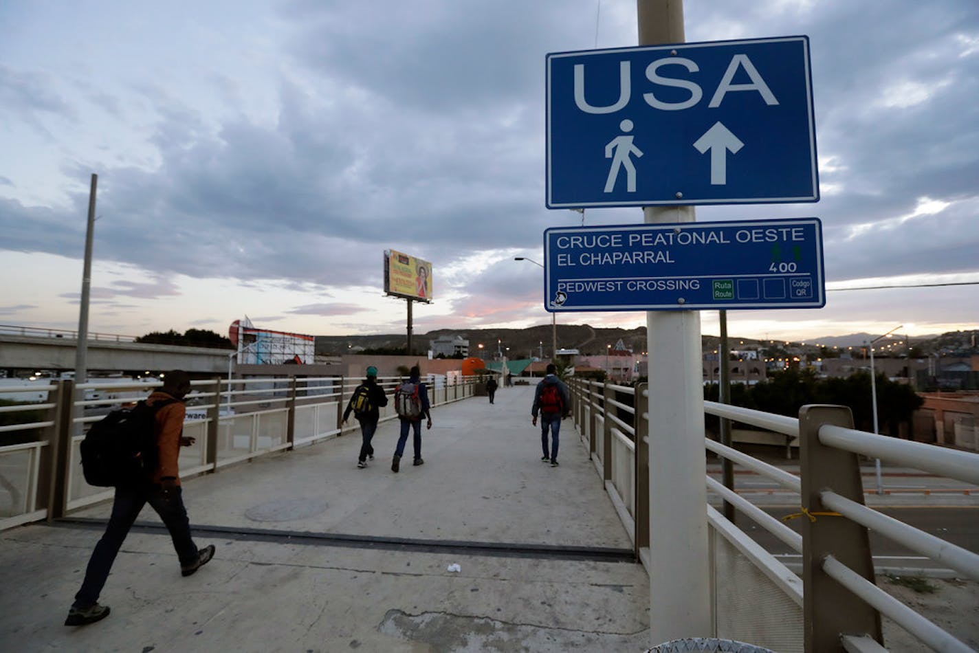 In this 2016 photo, Haitians make their way towards the border crossing in Tijuana, Mexico. The Trump administration is planning to expand the collection of DNA from migrants who cross the U.S. border, and to include the information in a massive criminal database operated by the FBI.