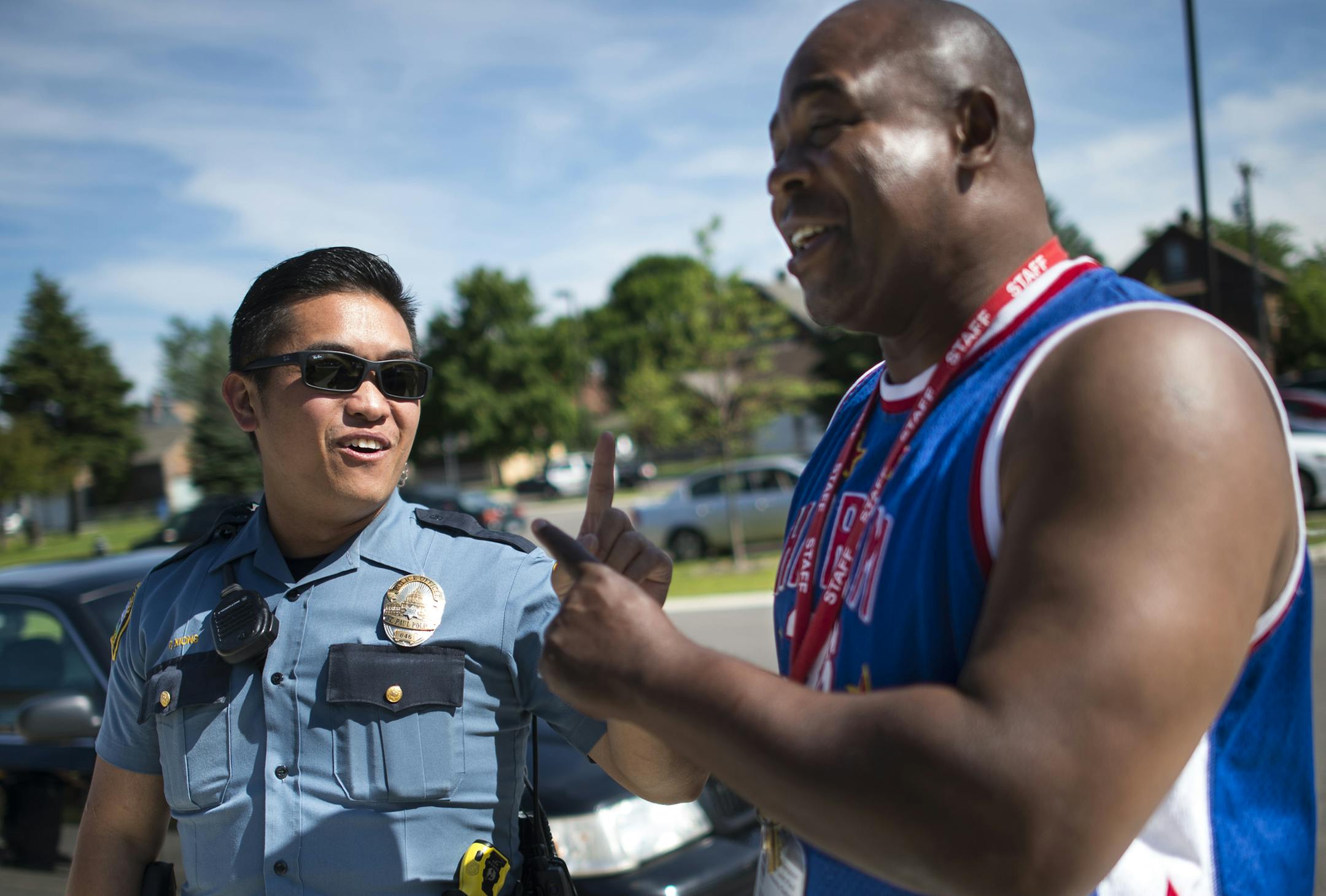 St. Paul police officer Pheng Xiong joked with Marcel Thompson, one of his high school teachers during Xiong’s wilder days as a youth. Above, Xiong shot baskets with Ronnie Kemp at a community center.