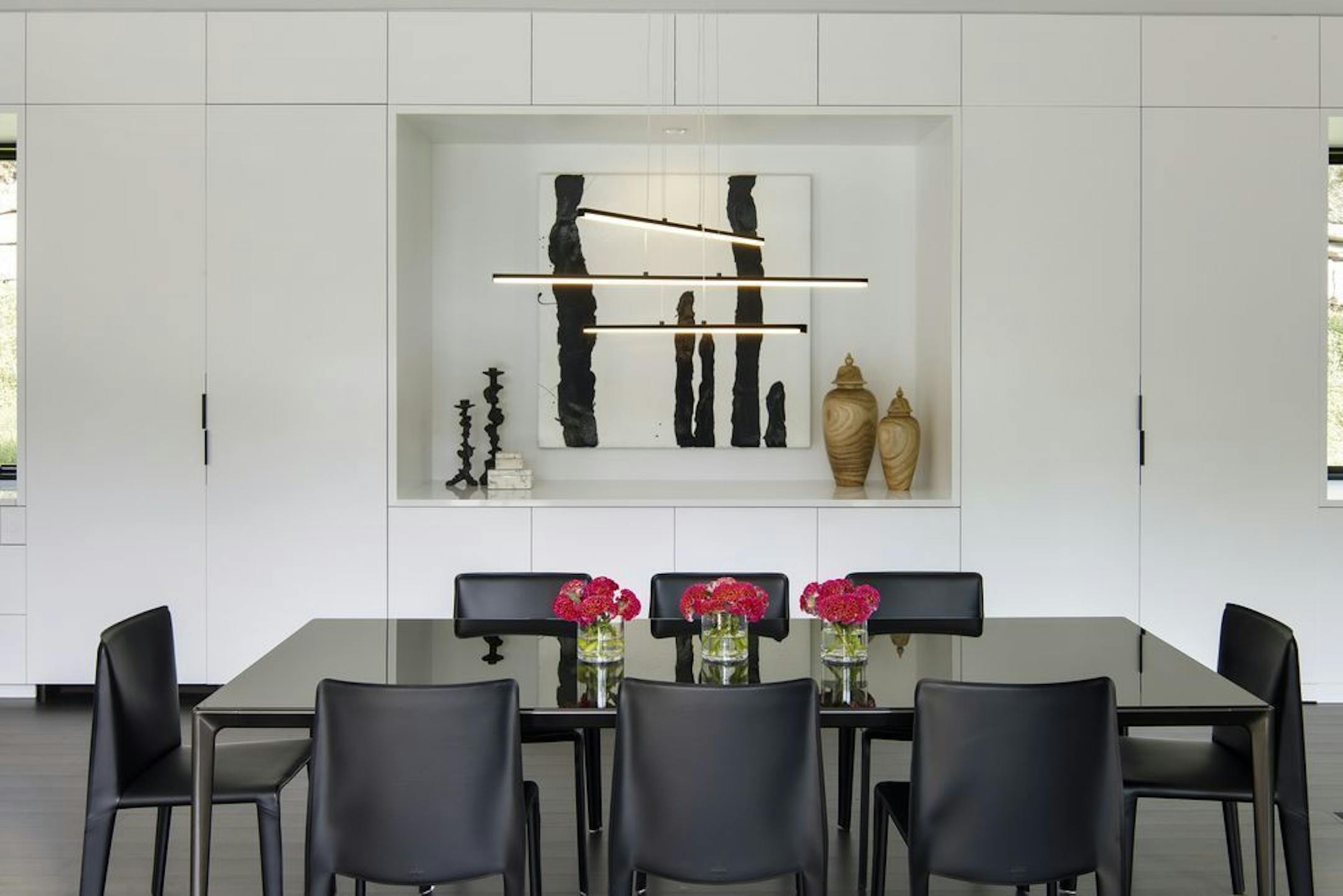 Pivoting pocket doors (closed in this photo) flank the art display niche in the dining area.