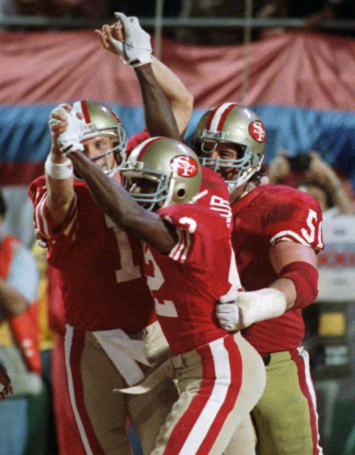 FILE - In this Jan. 22, 1989, file photo, San Francisco 49ers quarterback Joe Montana (16) and wide receiver John Taylor (82) clasp hands after Montana's pass to Taylor during the fourth quarter against the Cincinnati Bengals in NFL football's Super Bowl XXIII in Miami. (AP Photo/Rusty Kennedy, File) ORG XMIT: NY154