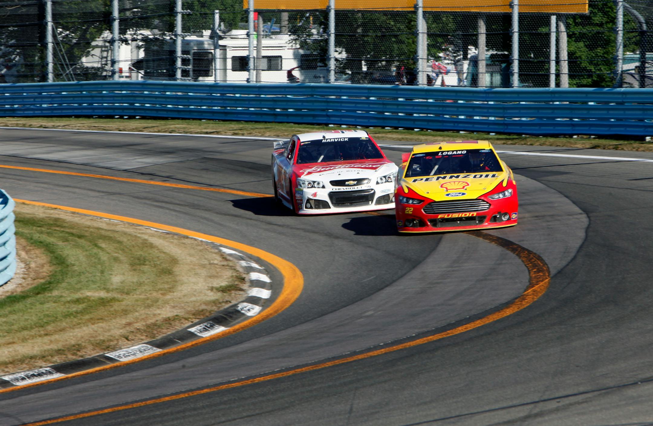 Joey Logano passed Kevin Harvick on the last turn on the way to winning a NASCAR Sprint Cup series auto race at Watkins Glen International on Sunday.