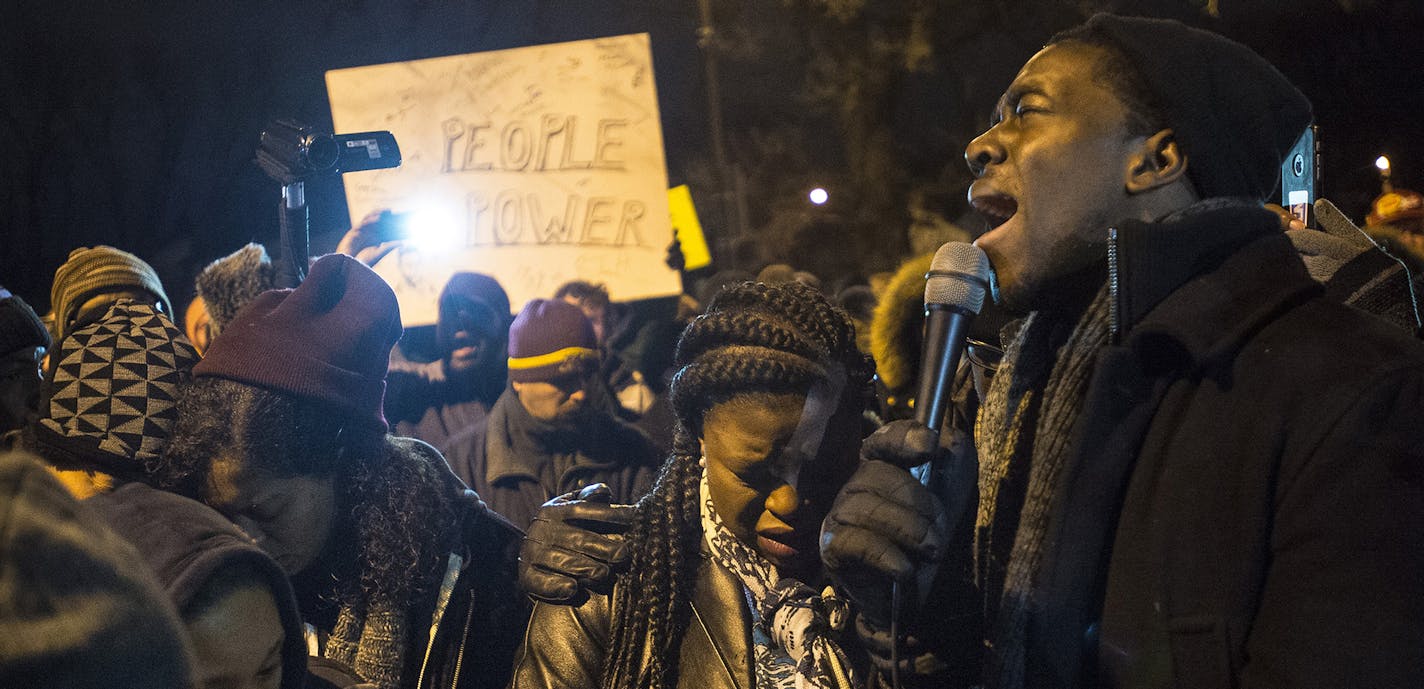 NAACP youth director Stephen Green, right, sings "We Shall Overcome" at the site of a memorial set up for Jamar Clark along Plymouth Avenue in north Minneapolis on Friday, Nov. 20, 2015. (Aaron Lavinsky/Minneapolis Star Tribune/TNS) ORG XMIT: 1176971 ORG XMIT: MIN1511202145420080