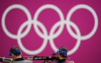 Sergey Kamenskiy, right, of the Russian Olympic Committee, competes in the men’s 10-meter air rifle at the Asaka Shooting Range in the 2020 Summer O