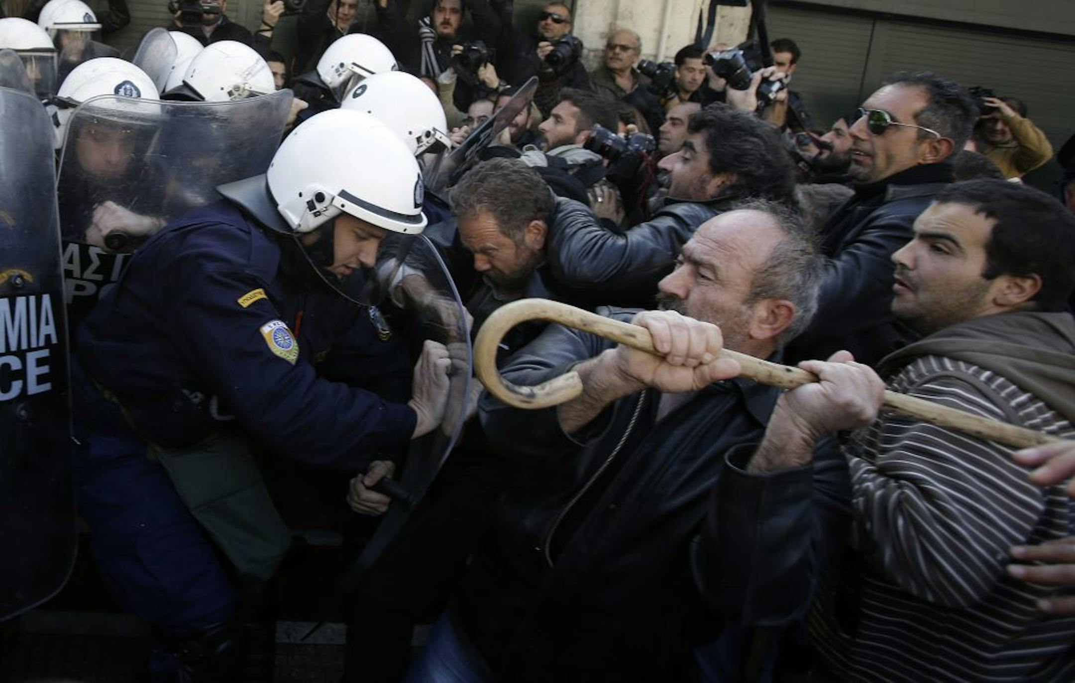 Farmers clash with riot police outside Greece's parliament in Athens on Friday, Dec. 20, 2013. Farmers from the island of Crete clashed with police as lawmakers prepared to vote on a new property tax that will extend the levy to include farms.