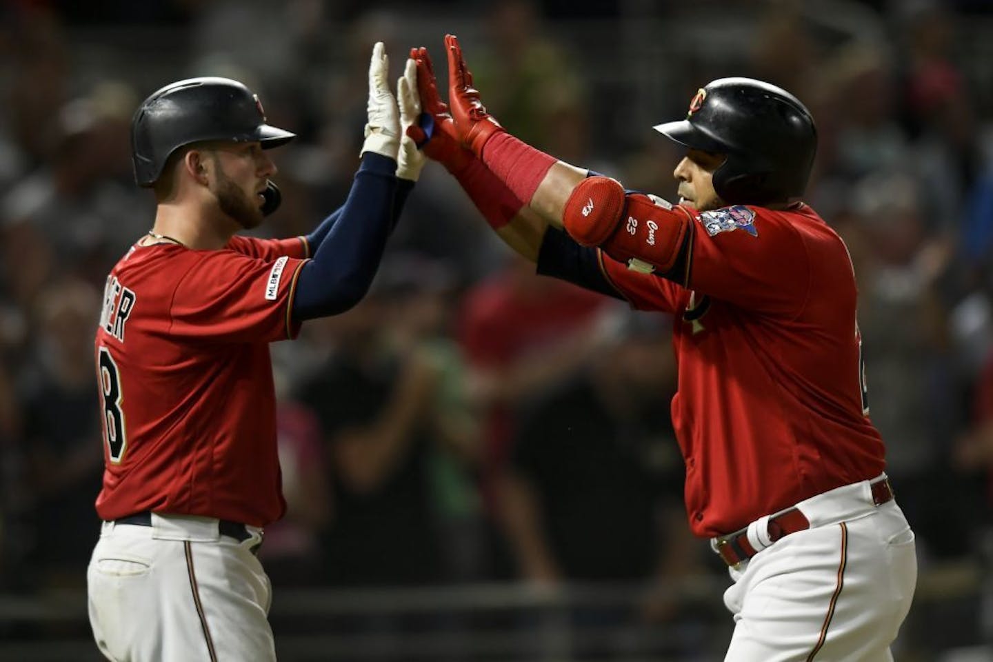 Minnesota Twins designated hitter Nelson Cruz (23) celebrated after he hit a two-run home run with catcher Mitch Garver (18), left, on base in the bottom of the seventh inning against the Kansas City Royals.