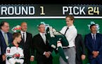 Filip Johansson, of Sweden, puts on a jersey after being selected by the Minnesota Wild during the NHL draft in Dallas