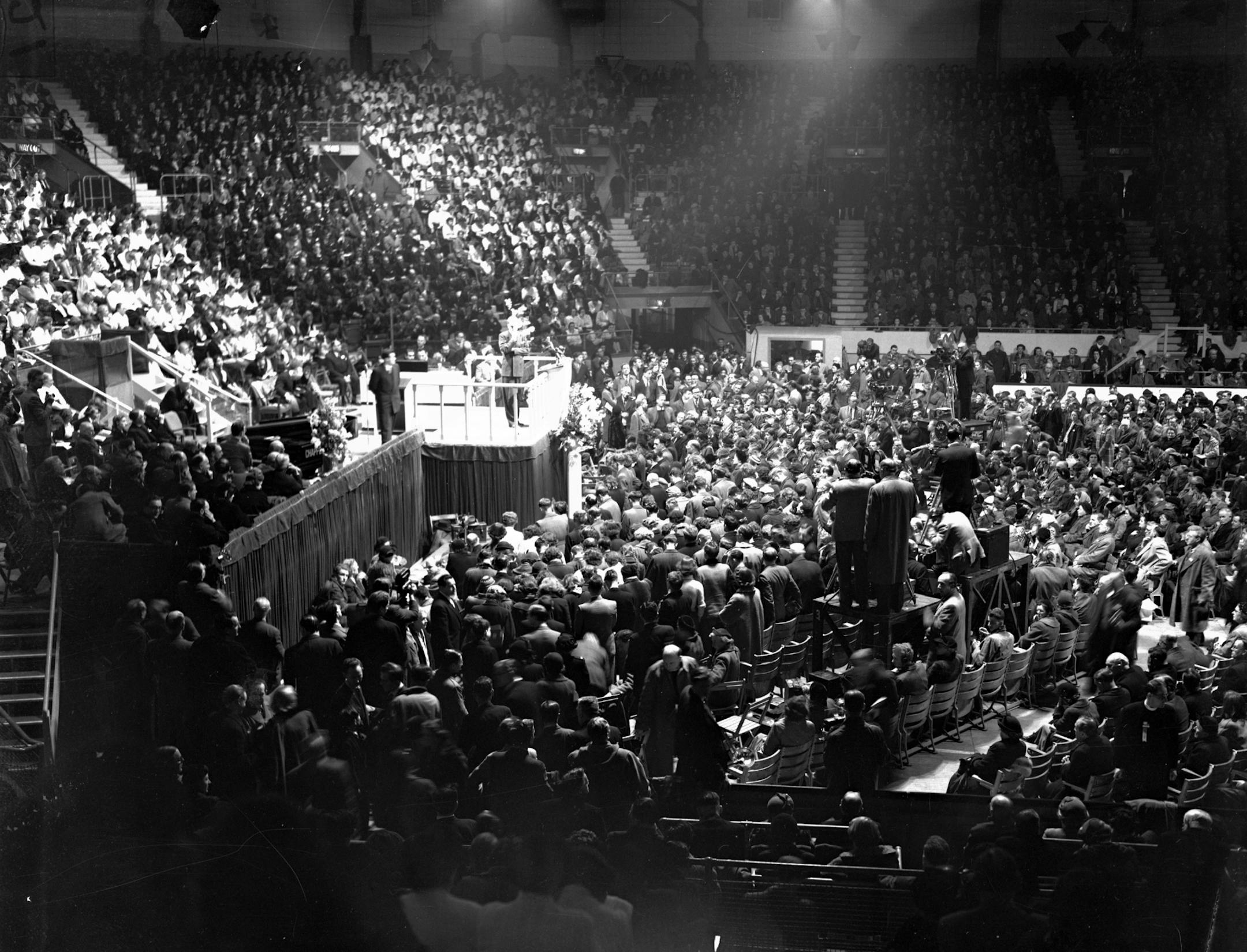 American evangelist Billy Graham stands on the rostrum at London's Harringay Arena, in this March 1, 1954 file photo. Plenty of people were suspicious when the evangelist arrived in London in February 1954 for a 12-week mission. But an estimated 2 million people attended the preacher's 72 rallies and up to 38,000 people _ more than half of them aged under 19 _ responded to his altar calls.