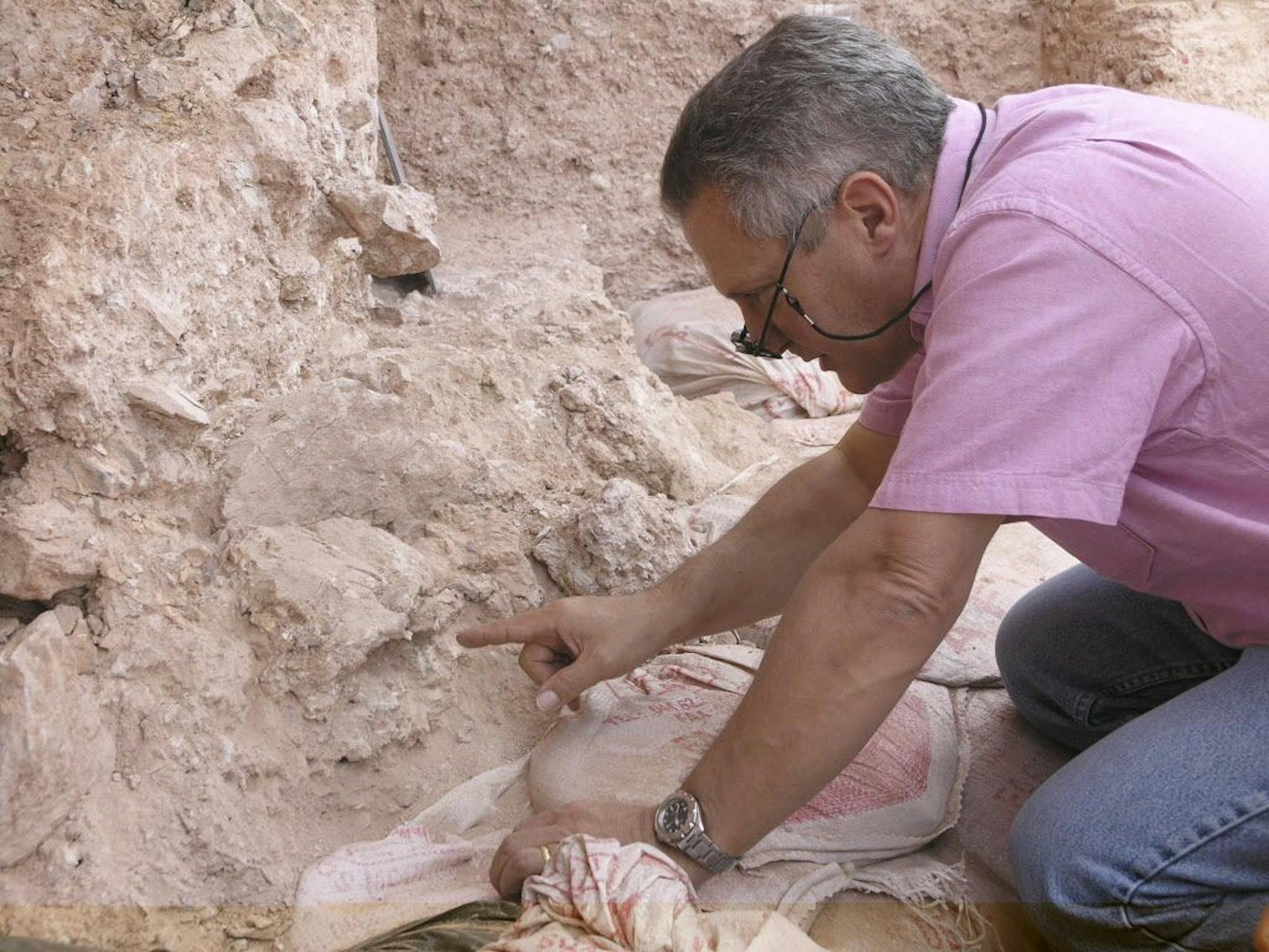 The March 16, 2007 photo provided by the Max Planck Institute for Evolutionary Anthropology shows Dr. Jean-Jacques Hublin on first seeing the new finds at the Jebel Irhoud site in Morocco where the oldest known fossils of human species have been unearthed. He is pointing to the crushed human skull (Irhoud 10) whose orbits are visible just beyond his finger tip.