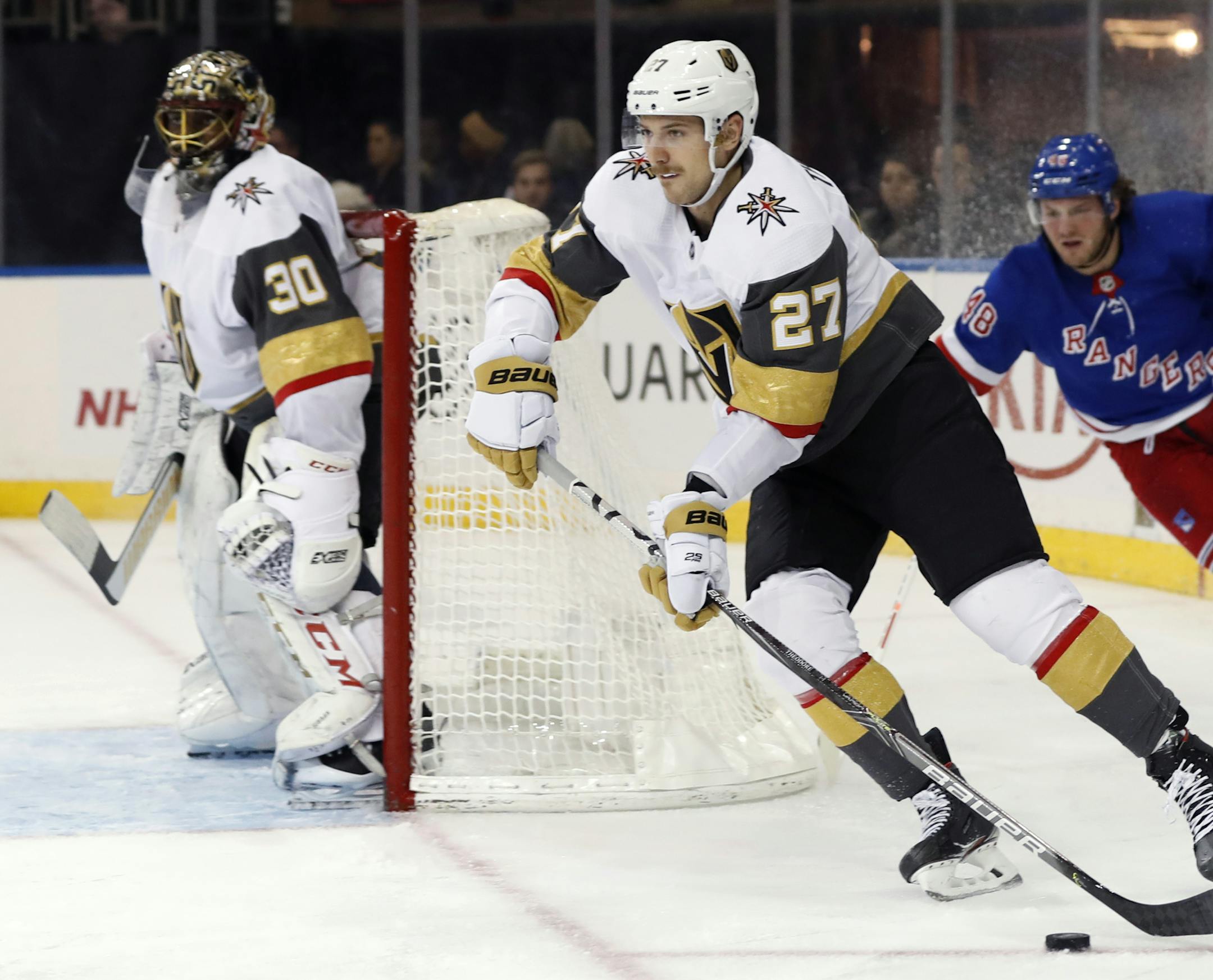 Vegas Golden Knights goalie Malcolm Subban (30), watches as Godlen Knights defenseman Shea Theodore (27) skates down ice leaving New York Rangers left wing Brendan Lemieux (48) behind during the second period of an NHL hockey game, Monday, Dec. 2, 2019, in New York. (AP Photo/Kathy Willens)