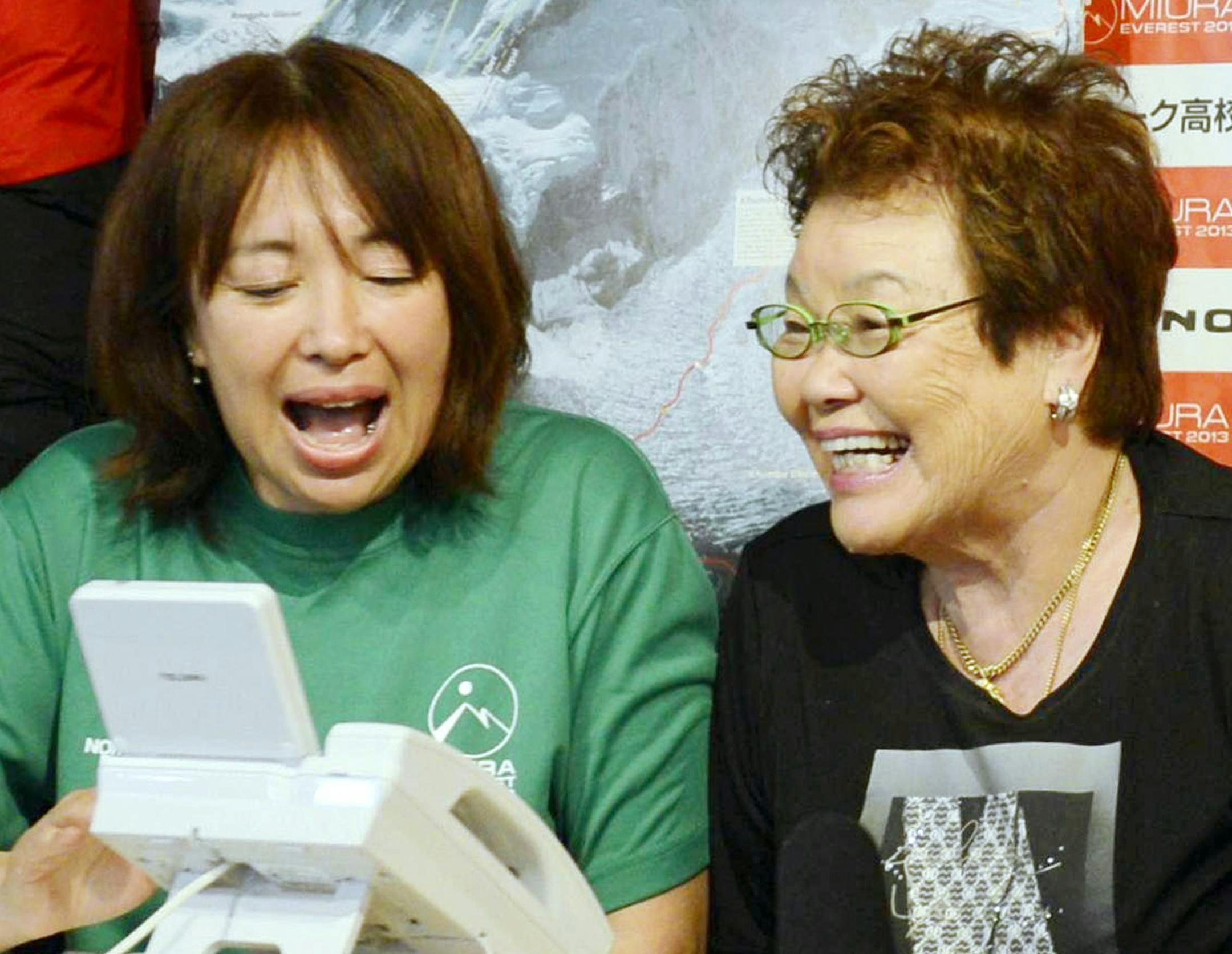 ADDS LOCATION - From left: Emiri Miura, daughter, and Tomoko Miura, wife of 80-year-old Japanese mountaineer Yuichiro Miura speaks with him immediately after he conquered the summit of Mount Everest, at Miura's office in Tokyo on Thursday, May 23, 2013. Miura on Thursday became the oldest person to reach the top of Mount Everest, although his record may last only a few days. An 81-year-old Nepalese man, who held the previous record, plans his own ascent next week. (AP Photo/Kyodo News) JAPAN OUT