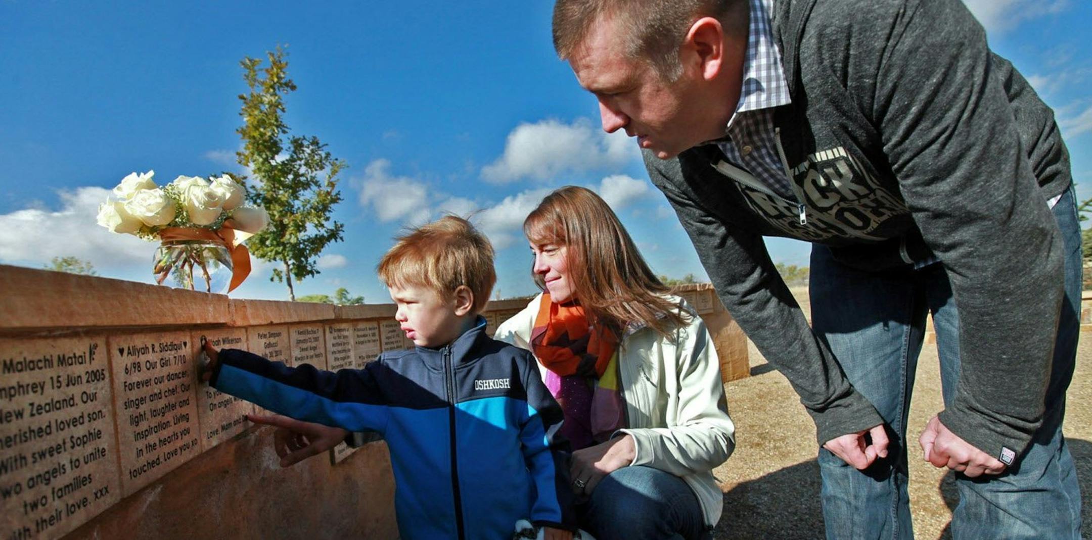 Aaron Wilkerson, 3, left, points to the memorial tile bearing the name of his older brother, Noah, as parents Sarah Wilkerson, center, and Chris look on, at the Rowan Tree Foundation Angel Memorial Plaza in Parker, Colo., Oct. 12, 2013. Noah died at the age of four days old from a rare metabolic disorder. (Kristyna Wentz-Graff/Milwaukee Journal Sentinel/MCT)