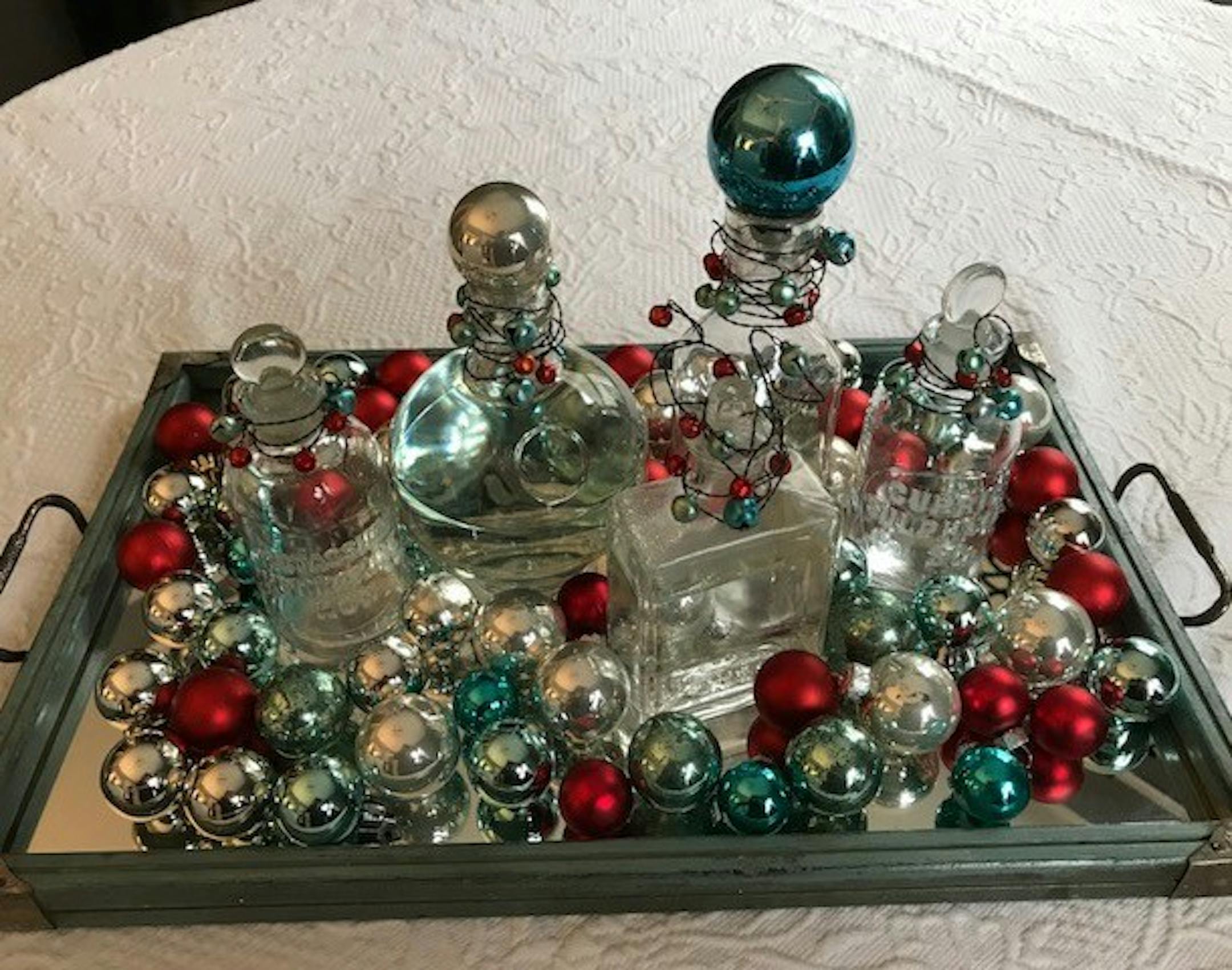 Fancy glass bottles are wrapped with jingle bells.