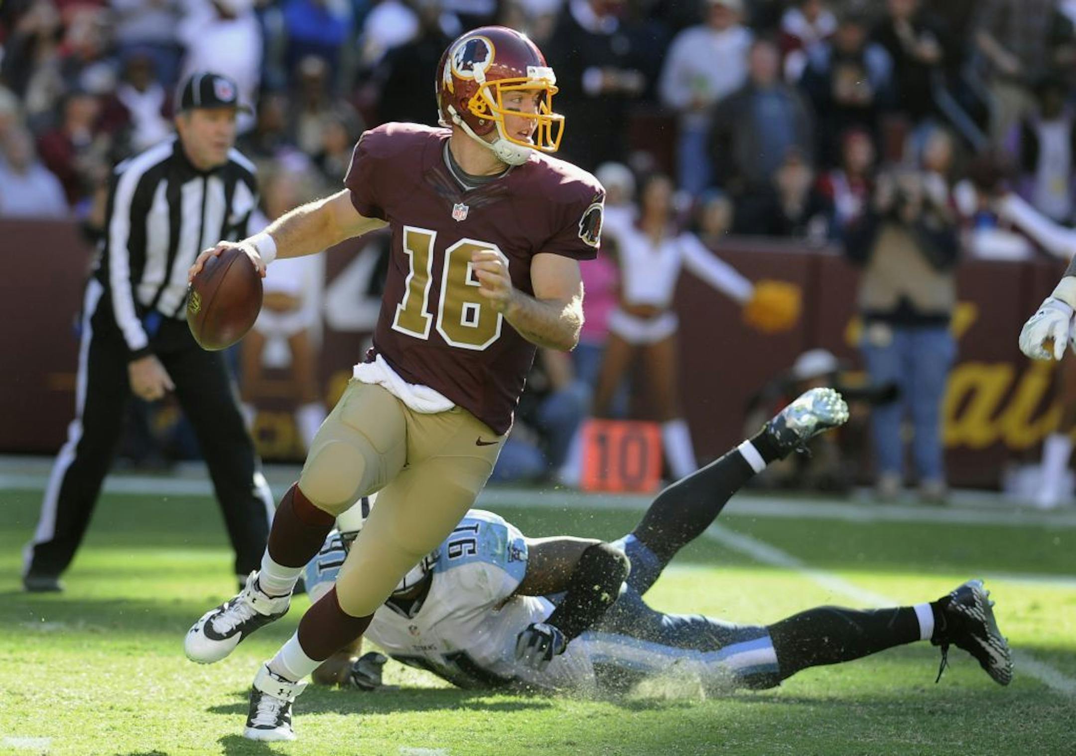 Washington Redskins quarterback Colt McCoy (16) scrambles away Tennessee Titans linebacker Derrick Morgan during the 4th quarter of their NFL football game, Sunday, Oct. 19, 2014, in Landover, Md. Redskins defeated the Titans 19-17.