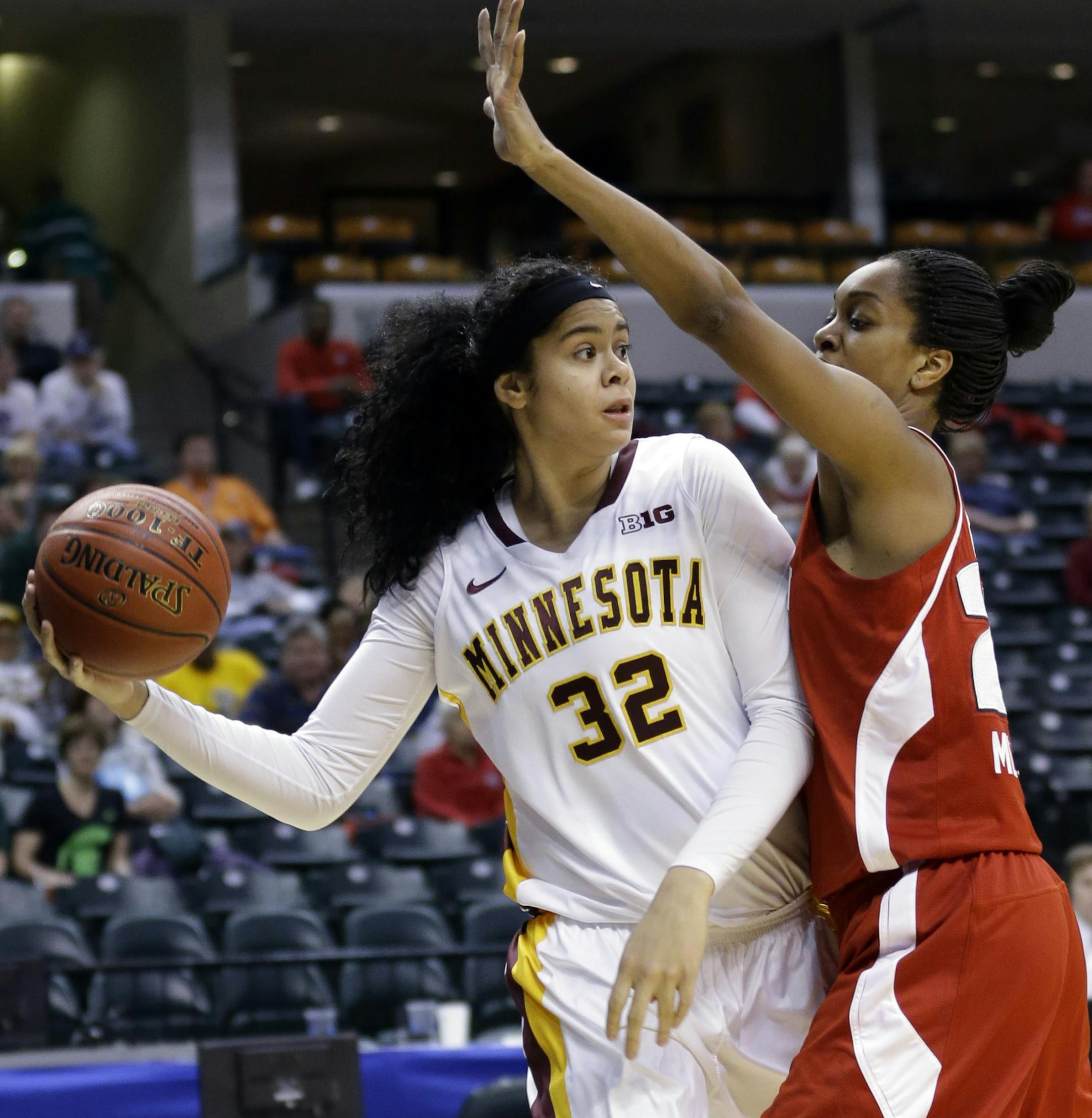 Minnesota center Amanda Zahui B., left, looks to pass around Wisconsin center Michala Johnson in the first half of an NCAA college basketball game in the opening round of the Big Ten Tournament in Indianapolis, Ind., Thursday, March 6, 2014. (AP Photo/Michael Conroy)