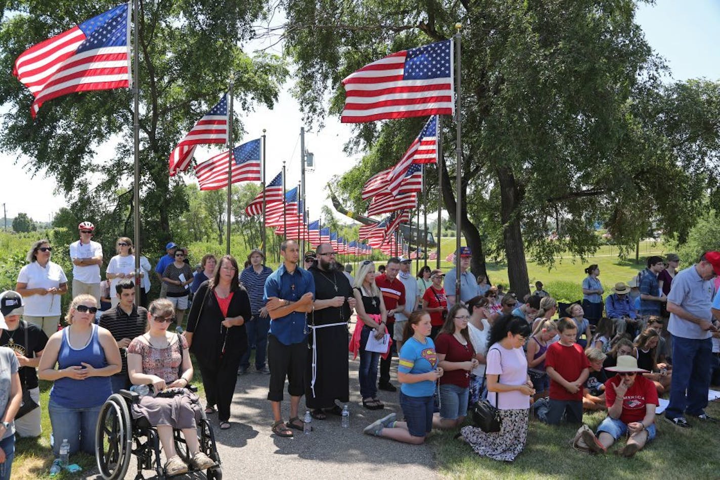 Catholic protesters gather at Veterans Memorial Park in Belle Plaine to protest inclusion of satanic symbol statute, part of a free-speech philosophical tug of war. The memorial depicting a soldier kneeling by a cross was removed Friday.