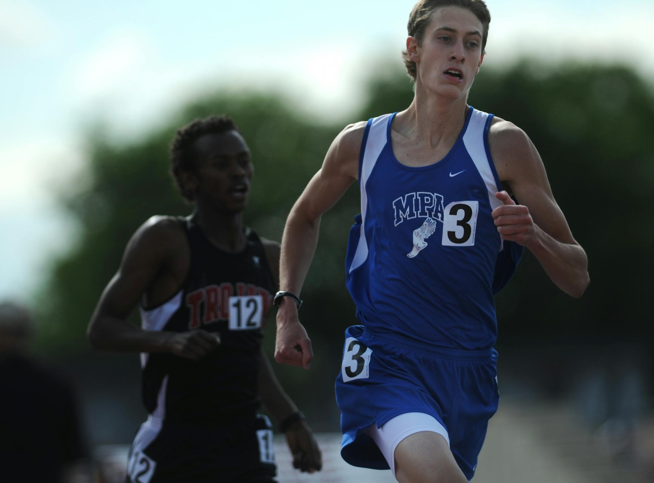 Mason Ferlic of Mounds Park, right, pulled ahead of the defending champion, Mubarik Musa of Worthington, left, in the A 1600-meter run during the final day of the boys' and girls' state track meet held at Hamline University. Ferlic placed first in the event.