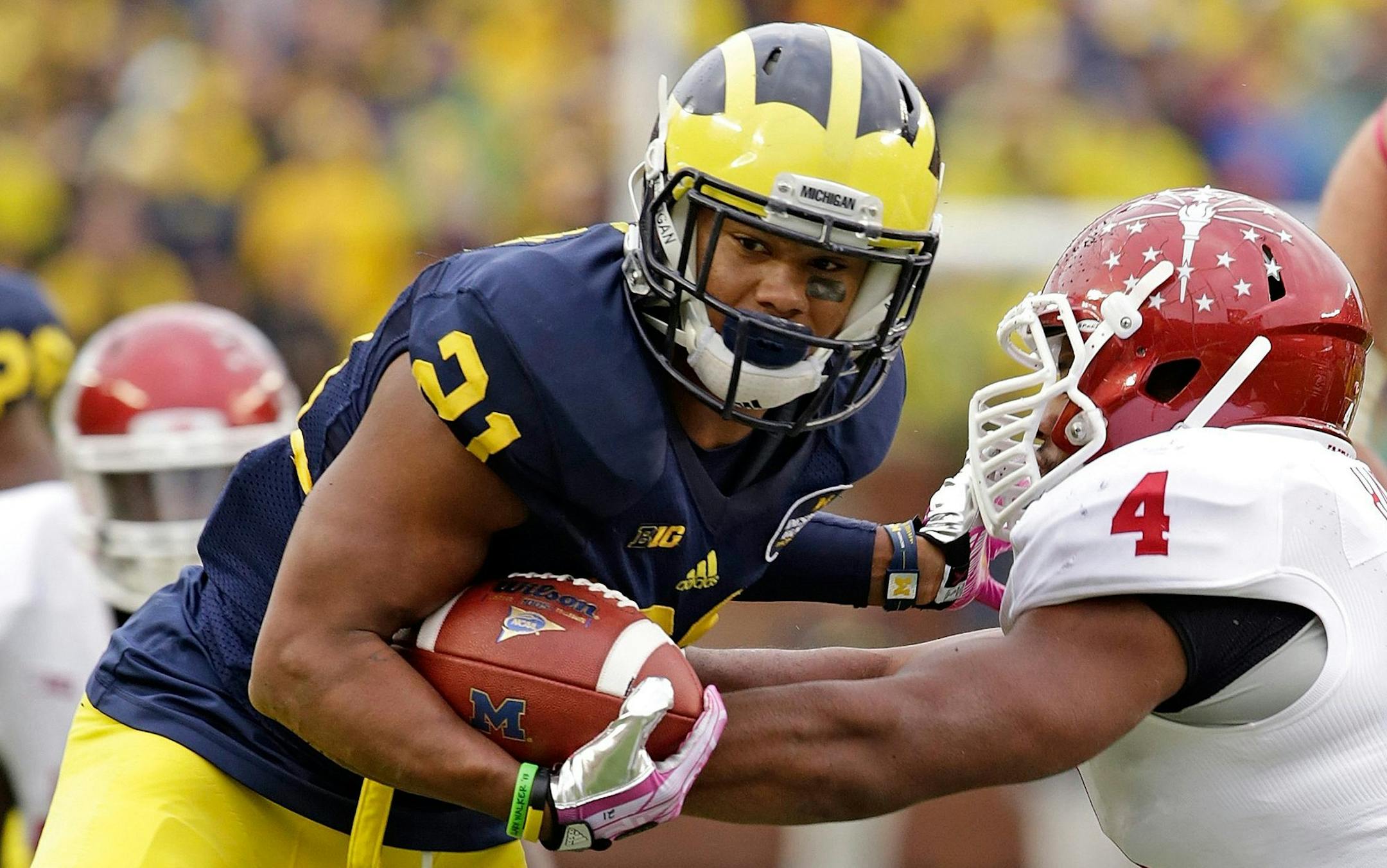 Michigan wide receiver Jeremy Gallon (21) stiff arms Indiana linebacker Forisse Hardin (4) in the second quarter at Michigan Stadium in Ann Arbor, Michigan, on Saturday, October 19, 2013. (Jarrad Henderson/Detroit Free Press/MCT)