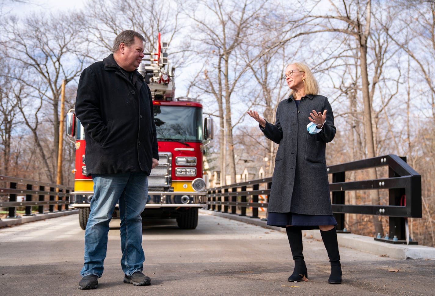 Deephaven City Councilor Steve Erickson listens to Minnesota Rep. Kelly Morrison during a grand opening and dedication ceremony of Northome Avenue bridge in honor of late Mayor Paul Skrede Thursday in Deephaven.