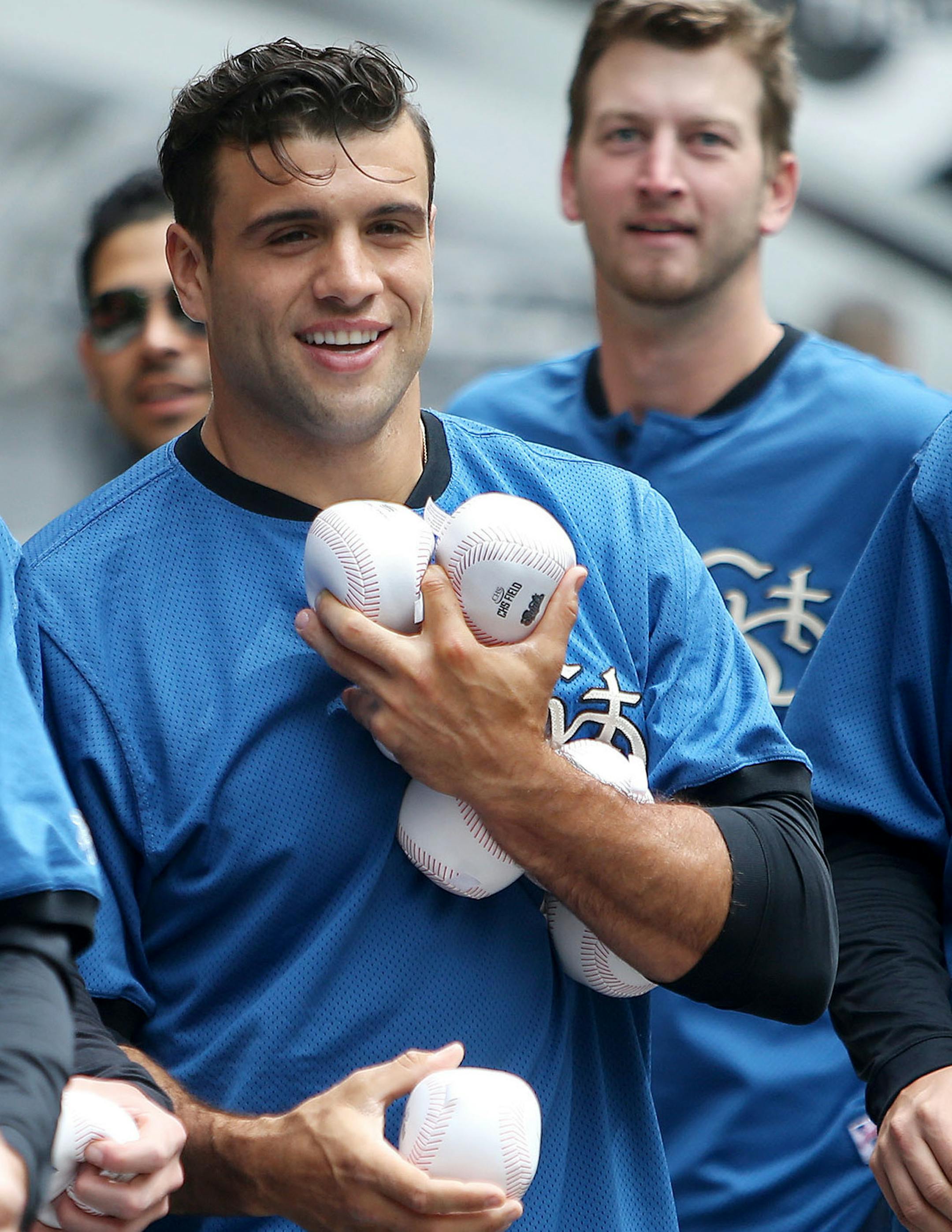 St. Paul Saints catcher Vincent DiFazio, center, is loaded down with soft baseballs that Saints players gave out to passersby before the start of the world's largest game of catch Wednesday, May 20, 2015 in Lowertown, near Mears Park in advance of the St. Paul Saints home opener Thursday.](DAVID JOLES/STARTRIBUNE)djoles@startribune.com world's largest game of catch in Lowertown, near Mears Park in advance of the St. Paul Saints home opener Thursday.**Vincent DiFazio,cq