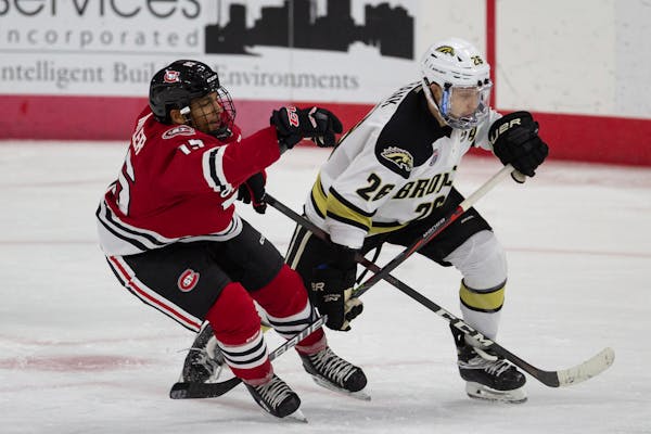 St. Cloud State forward Micah Miller (15) gets tangled up with Western Michigan forward Ethen Frank's (26) stick during an NCAA hockey game on Tuesday