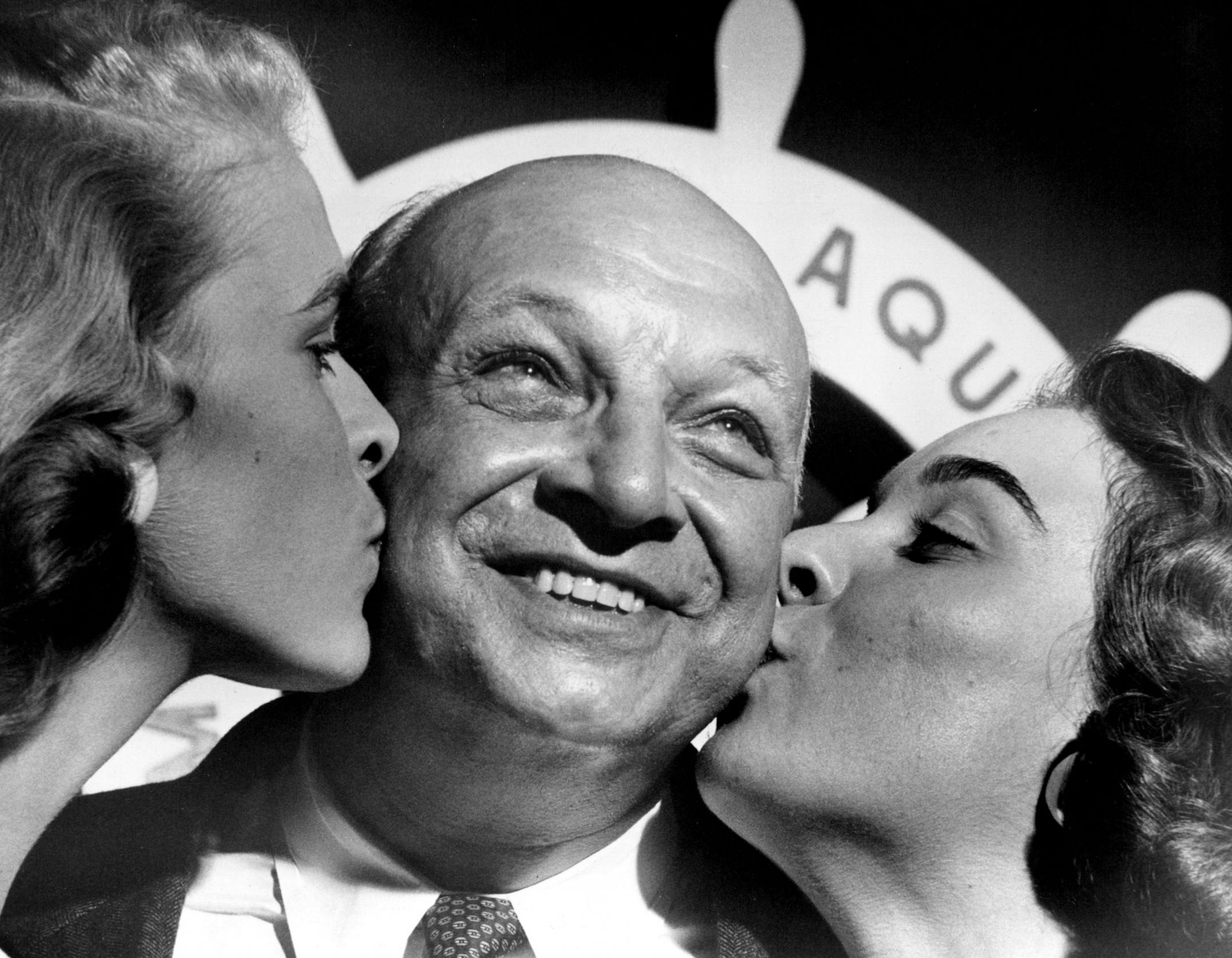 September 19, 1956: Aqua President Fremont W. Mitchell gets Queenly Kisses. Aquatennial Queen Mary Erickson, left, and past queen, Judy Penney, were contributors.