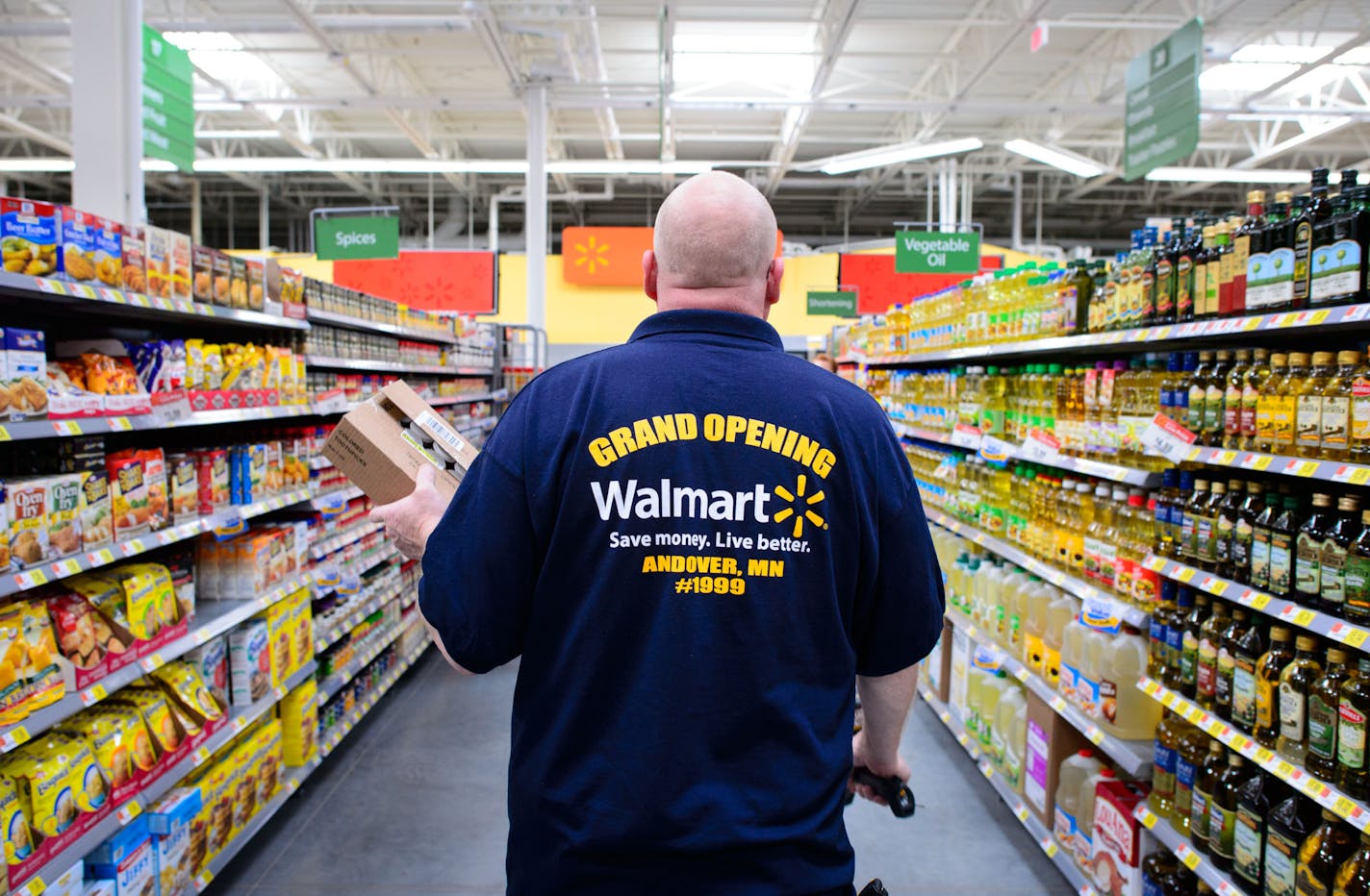 Associate Dan Kruger looked for the right spot on the grocery shelf to stock colored toothpicks. Walmart associates wore Grand Opening shirts on opening day at the new Andover Walmart, Wednesday, November 13, 2013. ] GLEN STUBBE * gstubbe@startribune.com