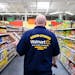 Associate Dan Kruger looked for the right spot on the grocery shelf to stock colored toothpicks. Walmart associates wore Grand Opening shirts on openi