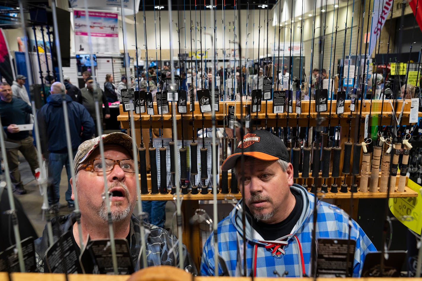 Tom Basham, left, and Scott McTaggart of Spooner, Wis. shop for rods at Joe's Sporting Goods at the St. Paul Ice Fishing and Winter Sports Show in St. Paul, Minn. Friday, Dec. 1, 2023. ] LEILA NAVIDI • leila.navidi@startribune.com