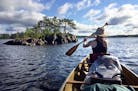 Val paddles past an island on the first day of canoeing –before the Thunderstorms struck.