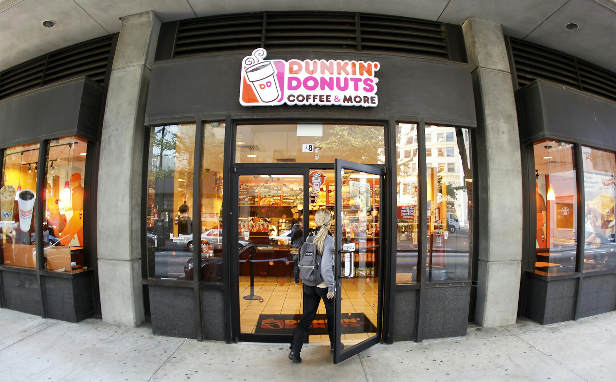 A customer enters a Dunkin' Donuts store Monday, Oct. 31, 2011, in Atlanta. Dunkin' Brands Group Inc., the parent of Dunkin' Donuts and the Baskin-Robbins ice cream chain, said Tuesday, Nov. 1, 2011, that its net income plummeted 61 percent in the July-to-September quarter, as the company paid charges related to going public and paying down debt. (AP Photo/John Bazemore) ORG XMIT: GAJB203