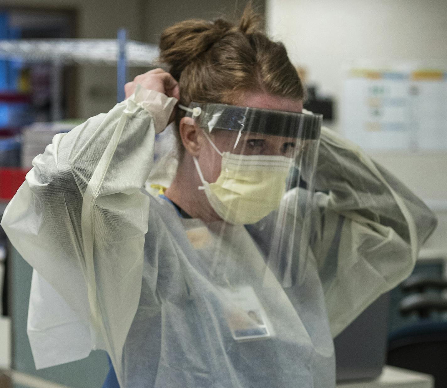 Registered nurse Lindsay Stewart showed the proper way to don PPE in the intensive care unit of Bethesda hospital, which has been converted into a COVID-19 treatment center.