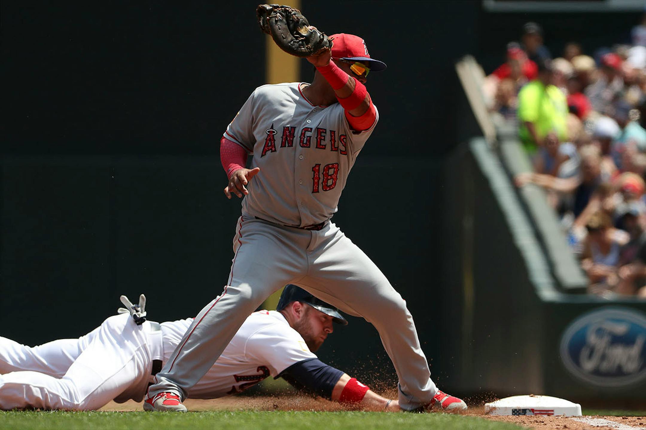 Los Angeles Angels first baseman Luis Valbuena (18) looked to tag out Minnesota Twins catcher Chris Gimenez (38) on the check at first in the second inning.