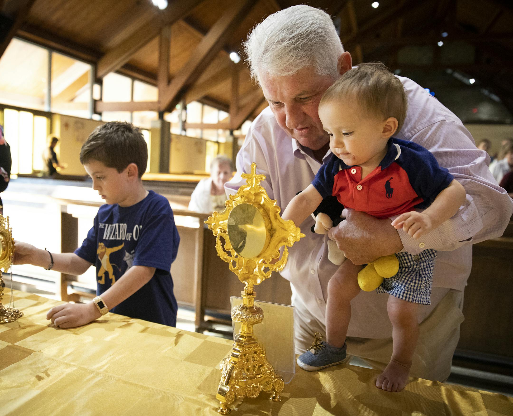 Jim Flannery of Shorewood holds his 15-month-old grandson Joey Ryan Flannery, of Chaska, to touch a fragment of the veil of the Blessed Virgin Mary ] LEILA NAVIDI ï leila.navidi@startribune.com BACKGROUND INFORMATION: Treasures of the Church visits St. John the Baptist Catholic Parish in Excelsior on Wednesday, May 30, 2018. Treasures of the Church is a traveling exposition that gives parishioners a chance to venerate the relics of some of their favorite saints.