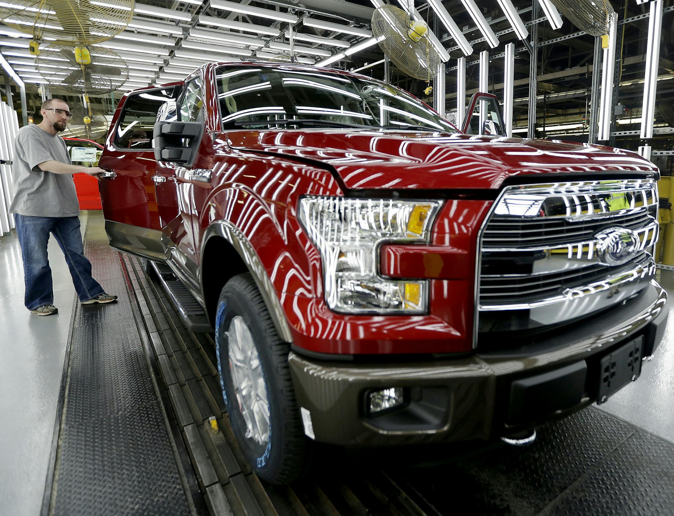 FILE - In this March 13, 2015, file photo, a worker inspects a new 2015 aluminum-alloy body Ford F-150 truck at the company's Kansas City Assembly Plant in Claycomo, Mo. U.S. safety regulators are investigating whether a recall of Ford F-150 pickup trucks for brake failures should be expanded to more model years. The probe covers about 282,000 pickups with 3.5-liter six-cylinder engines from 2015 and 2016. (AP Photo/Charlie Riedel, File) ORG XMIT: NYBZ206