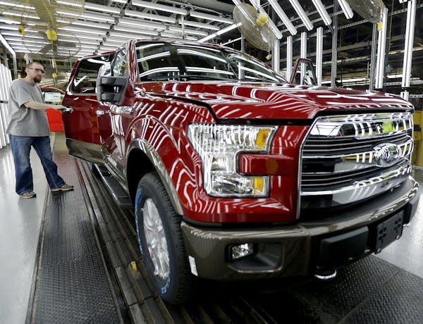 FILE - In this March 13, 2015, file photo, a worker inspects a new 2015 aluminum-alloy body Ford F-150 truck at the company's Kansas City Assembly Pla