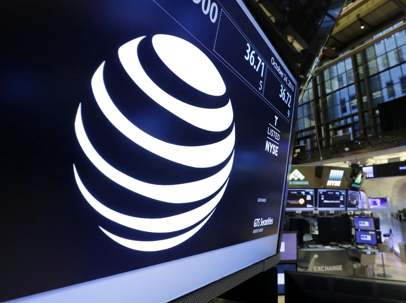 The AT&T logo appears above the post where it trades on the floor of the New York Stock Exchange, Monday, Oct. 24, 2016. AT&T's $85.4 billion purchase of Time Warner represents a new bet on synergy between companies that distribute information and entertainment to consumers and those that produce it. (AP Photo/Richard Drew) ORG XMIT: NYRD102