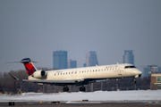 A Delta commercial airliner landed in front of the Minneapolis skyline at Minneapolis-St. Paul International Airport in 2021.