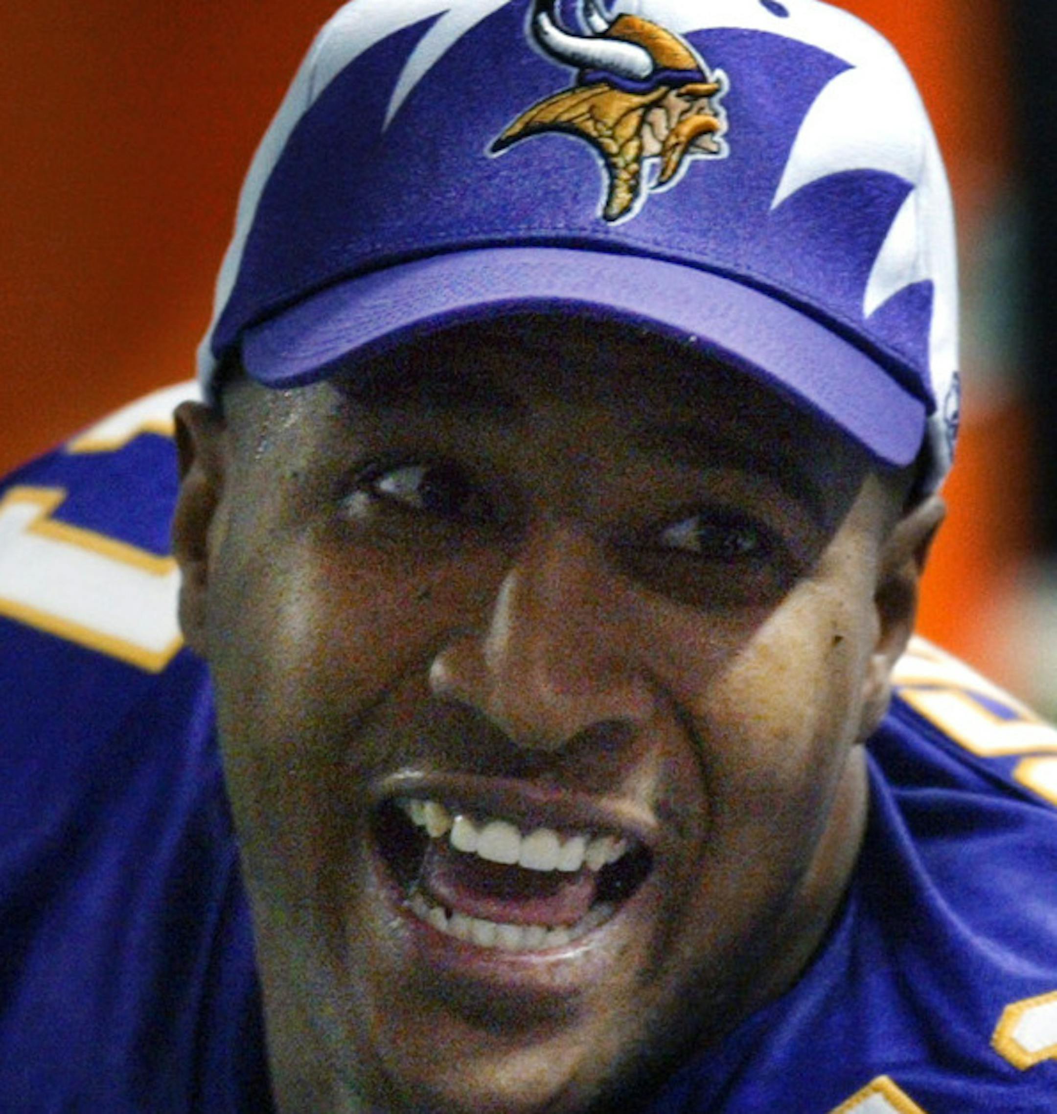 Viking quarterback Dante Culpepper , left, is all smiles on the bench during the third quarter as he talks to wide receiver Randy Moss and another teammate following Culpepper's second touchdown pass of the day to Moss. GENERAL INFORMATION: 12/7/03- Minneapolis, Mn - Seattle Seahawks vs. MN Vikings at the Metrodome.