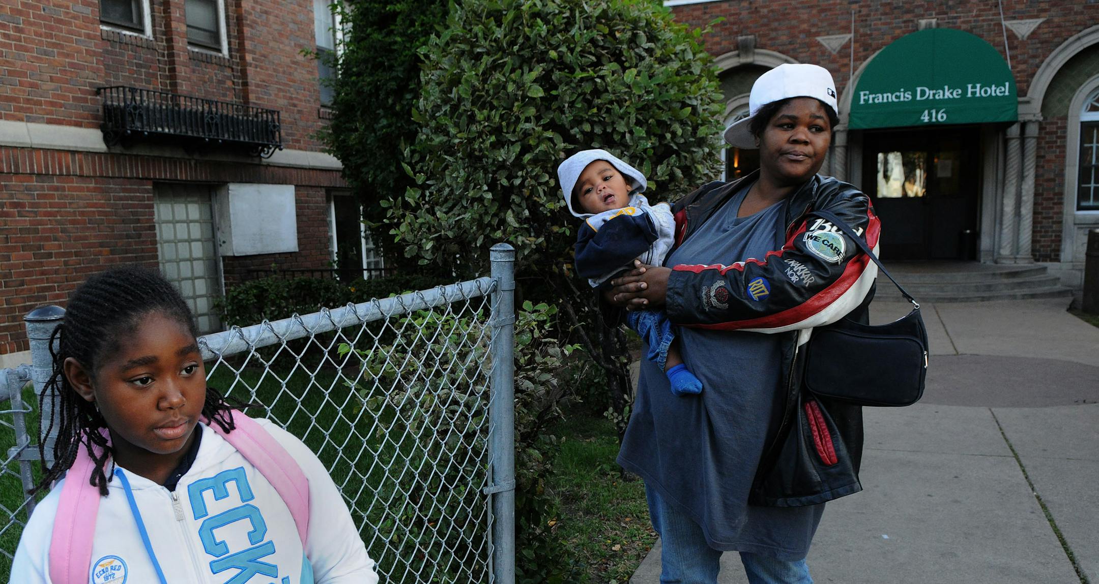 Minnie Rulford and her children: Lyteanetta, 12 & Arzell, 8 months wait for the school bus in front of the Drake Hotel. When asked about their stay in the Drake "It's hell," Rulford said. "It's nasty, it's filthy, it stinks." Rulford said her her room wasn't clean when she moved into the hotel two weeks ago. She asked her mother to bring cleaning supplies to hotel because the ones that were available there weren't sufficient.