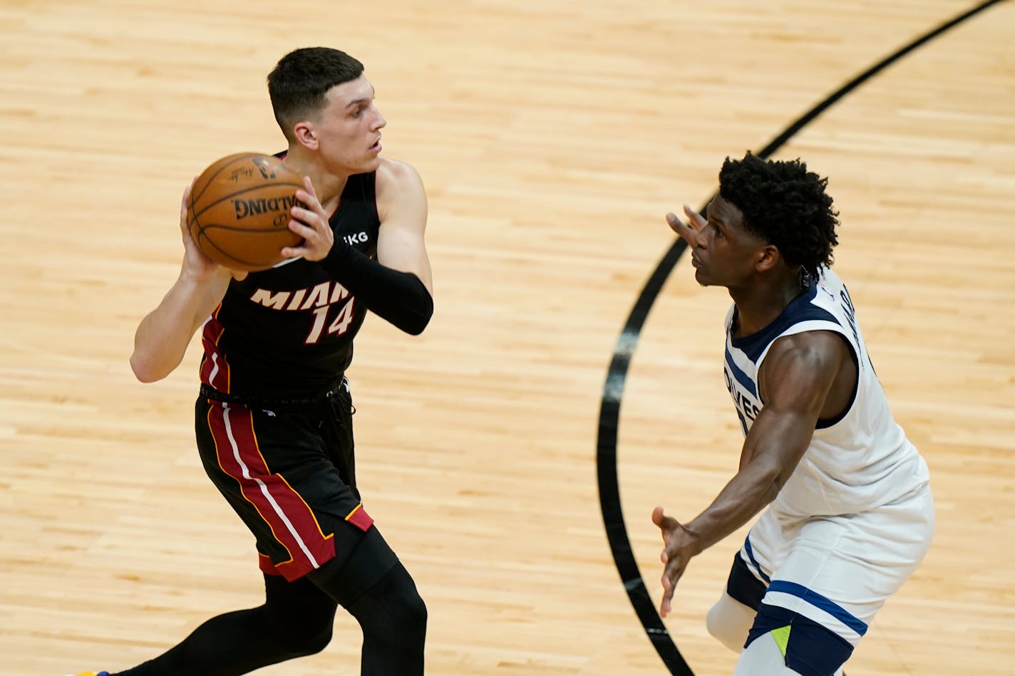 Miami Heat guard Tyler Herro (14) looks for an open teammate past Minnesota Timberwolves guard Anthony Edwards