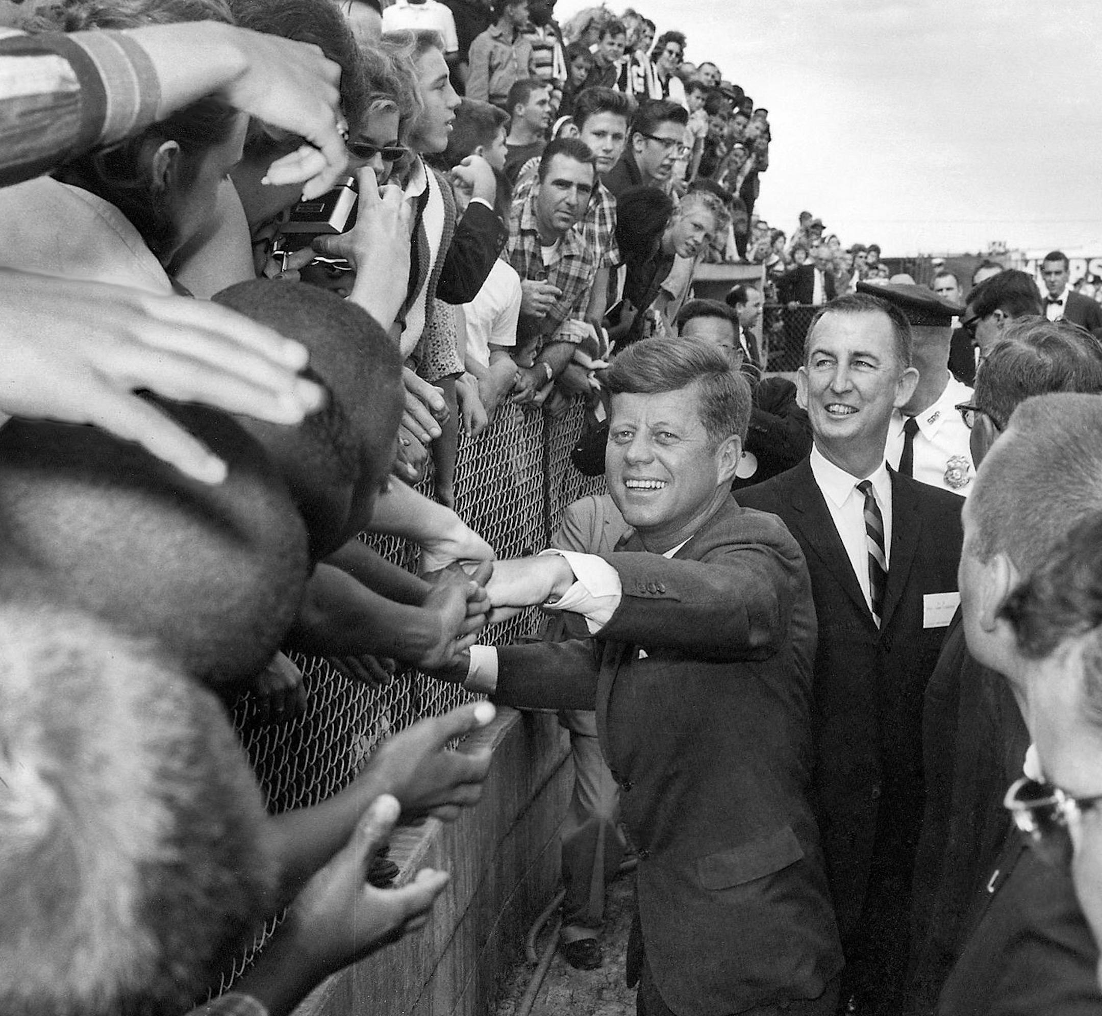 In this image made available by Tony Zappone, President John F. Kennedy shakes hands of spectators in Tampa, Fla. on Nov. 18, 1963. President Kennedy was in Tampa to give a speech commemorating the 50th anniversary of the first scheduled passenger airplane flight. A film and photo exhibit at the Tampa Bay History Center, documents those few hours he spent in Tampa. (AP Photo/Tony Zappone, HO) ORG XMIT: MIN2013111515234265