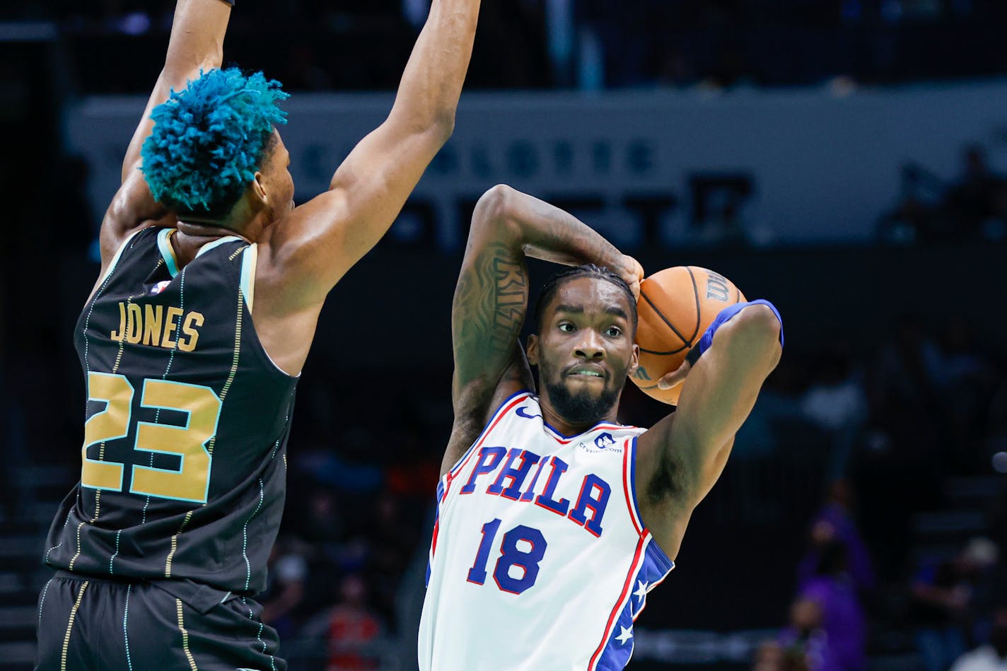 Philadelphia 76ers guard Shake Milton (18) passes around Charlotte Hornets forward Kai Jones (23) during the second half of an NBA basketball game in Charlotte, N.C., Friday, March 17, 2023. Philadelphia won 121-82. (AP Photo/Nell Redmond)