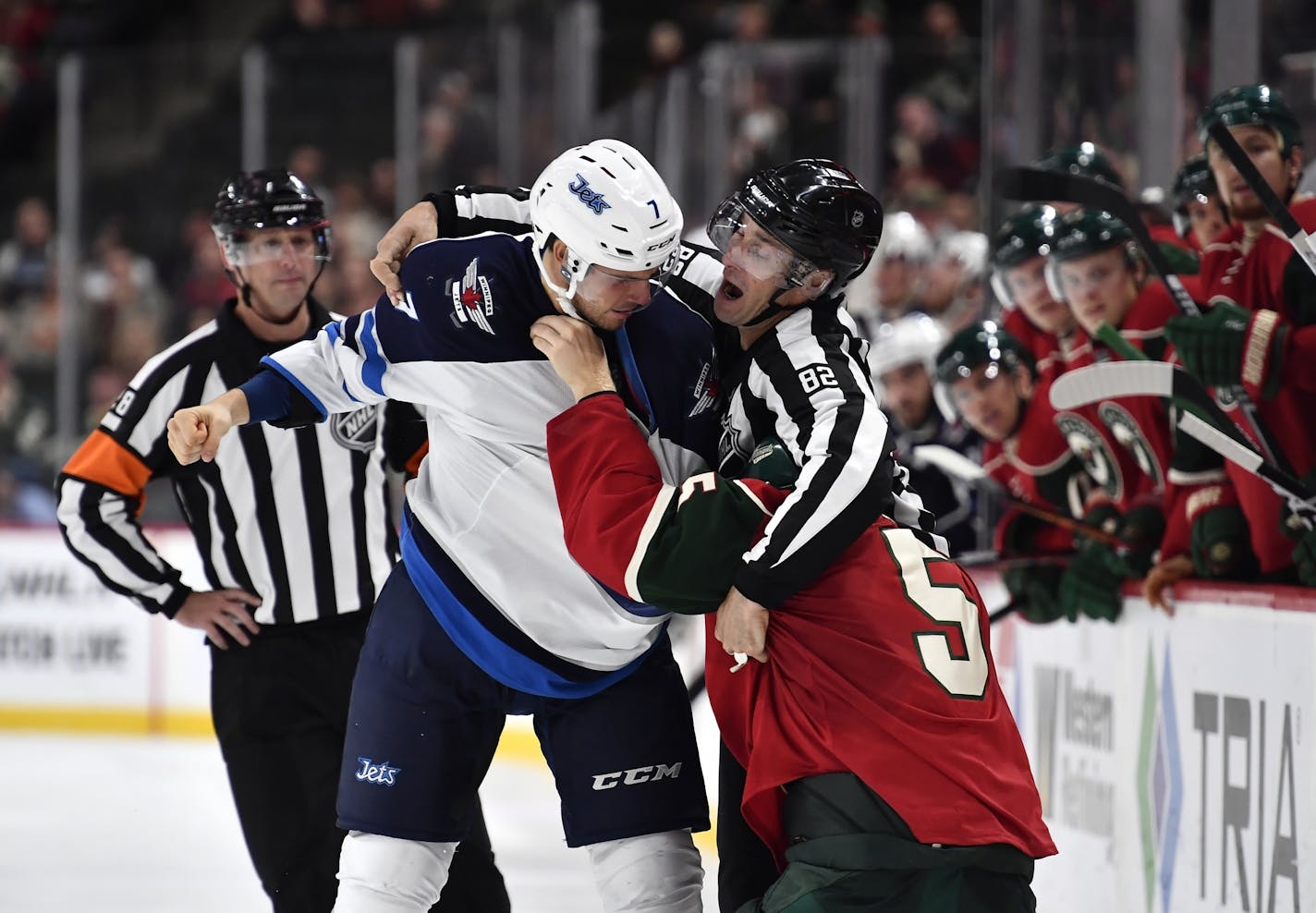 Linesman Ryan Galloway tried to separate Jets defenseman Ben Chiarot (7) and Wild defenseman Christian Folin (5) during a fight in the third period in a preseason game.