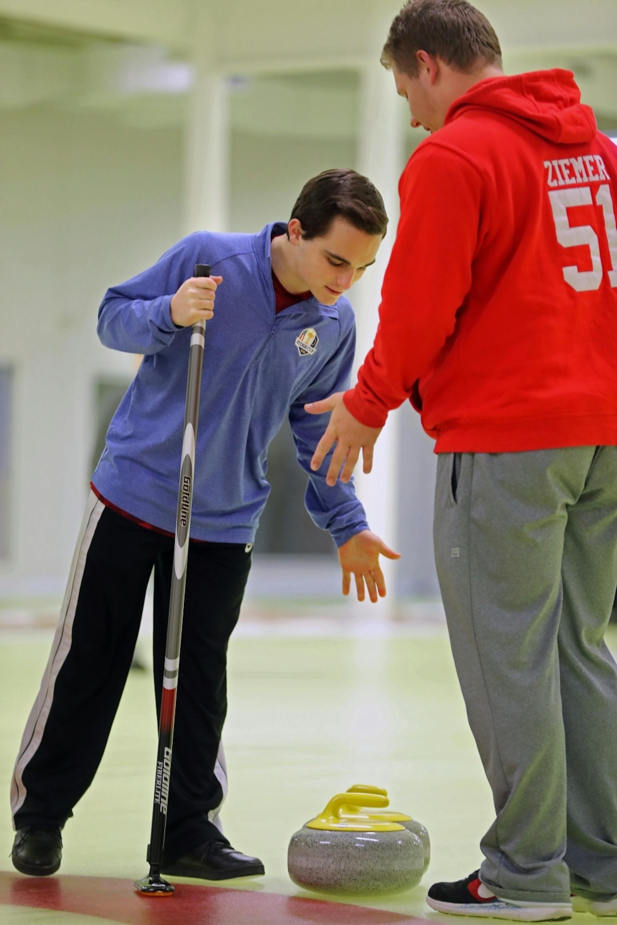 Levi Rosenthal and Jeremy Ziemer and students are Lakeville North who started club sport of curling at their school. They were helping novices learn the game.