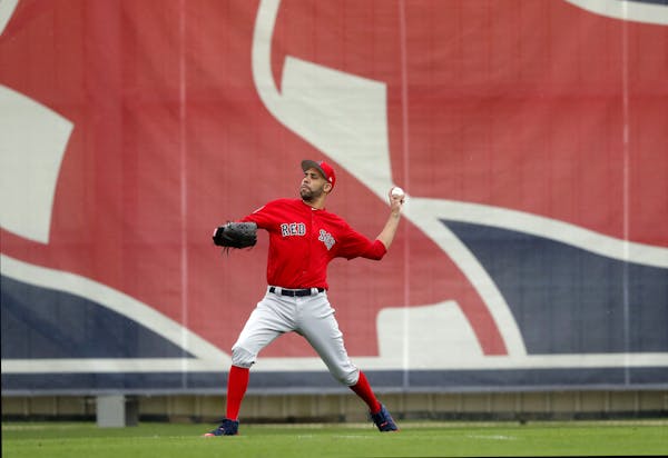 Boston Red Sox starting pitcher David Price warms up as pitchers and catchers reportde for their first workout at their spring training baseball facil